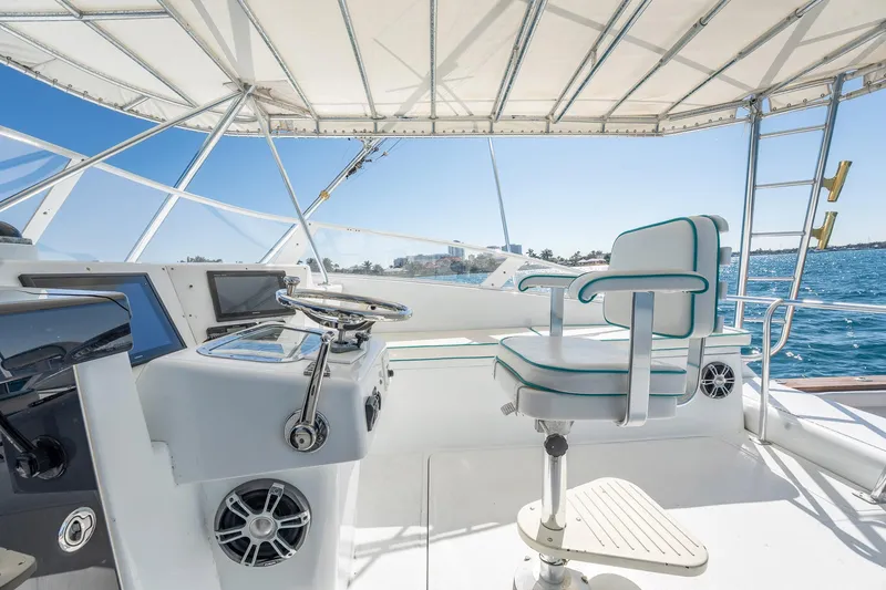 It Is Well Yacht Photos Pics Helm of 1997 Strike 42 Express yacht with steering wheel and captain's chair.