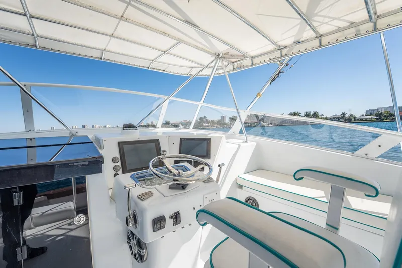 It Is Well Yacht Photos Pics Helm of 1997 Strike 42 Express boat with dual screens, steering wheel, and seating.