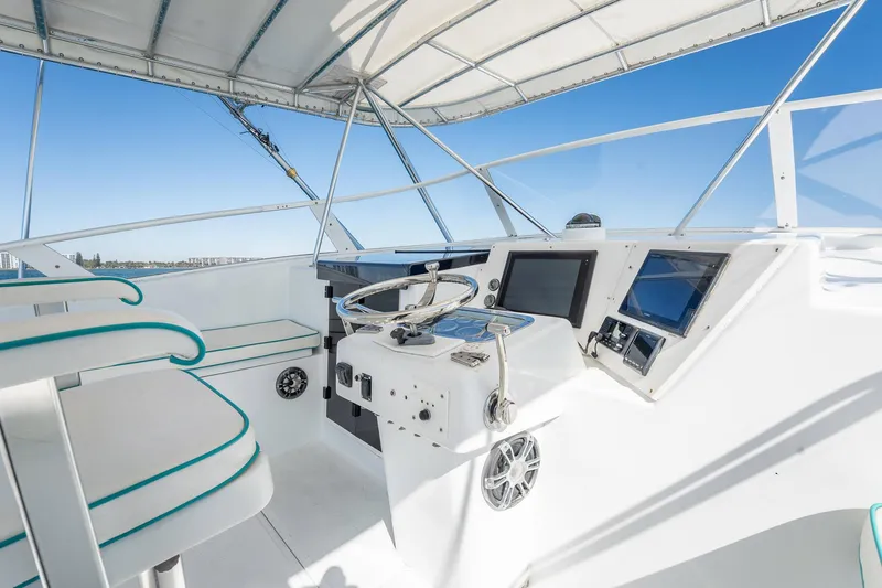 It Is Well Yacht Photos Pics 1997 Strike 42 Express boat helm with modern controls and seating under a canopy.