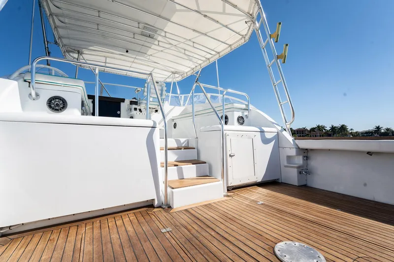 It Is Well Yacht Photos Pics 1997 Strike 42 Express yacht deck with wooden flooring and white railings under clear blue sky.
