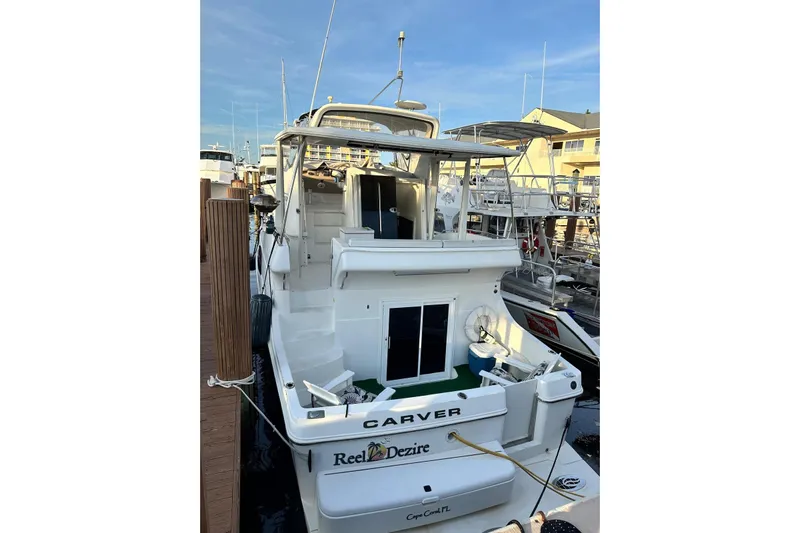 Reel Dezire Yacht Photos Pics 2005 Carver 41 Cockpit Motor Yacht docked, rear view with spacious deck and seating area.
