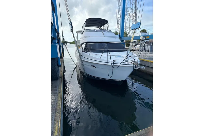 Reel Dezire Yacht Photos Pics 2005 Carver 41 Cockpit Motor Yacht docked in a marina, front view.
