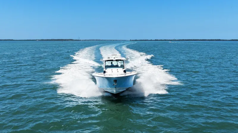  Yacht Photos Pics 2023 Grady-White Canyon 456 boat cruising on open water under clear blue sky.