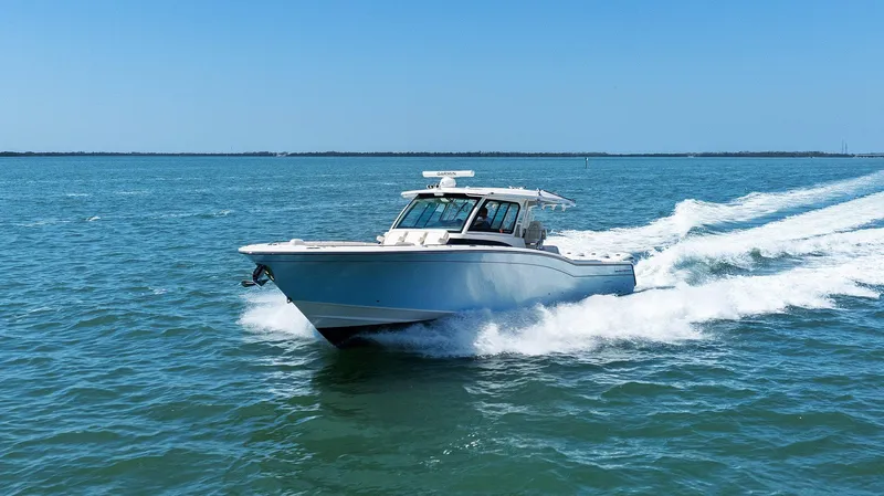  Yacht Photos Pics 2023 Grady-White Canyon 456 boat cruising on open water under clear blue skies.