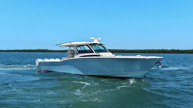  Yacht Photos Pics 2023 Grady-White Canyon 456 boat cruising on open water under clear blue sky.