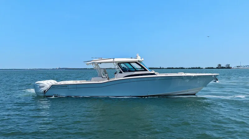  Yacht Photos Pics 2023 Grady-White Canyon 456 boat cruising on open water under clear blue sky.