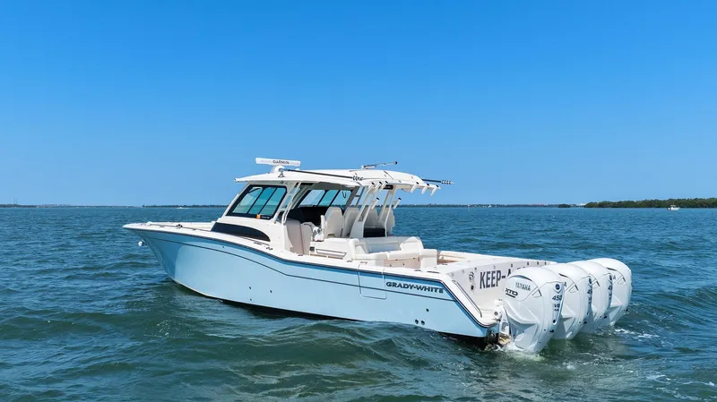  Yacht Photos Pics 2023 Grady-White Canyon 456 boat cruising on open water under clear blue sky.