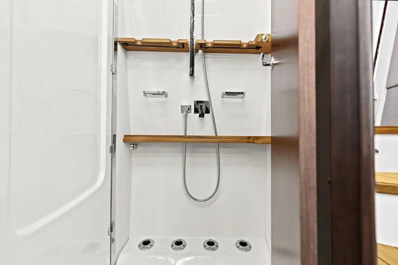  Yacht Photos Pics 2023 Grady-White Canyon 456 shower with modern fixtures and wooden accents.
