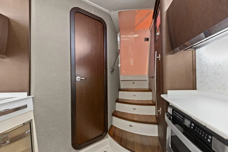  Yacht Photos Pics Interior of 2023 Grady-White Canyon 456 boat, featuring wooden stairs and modern cabinetry.
