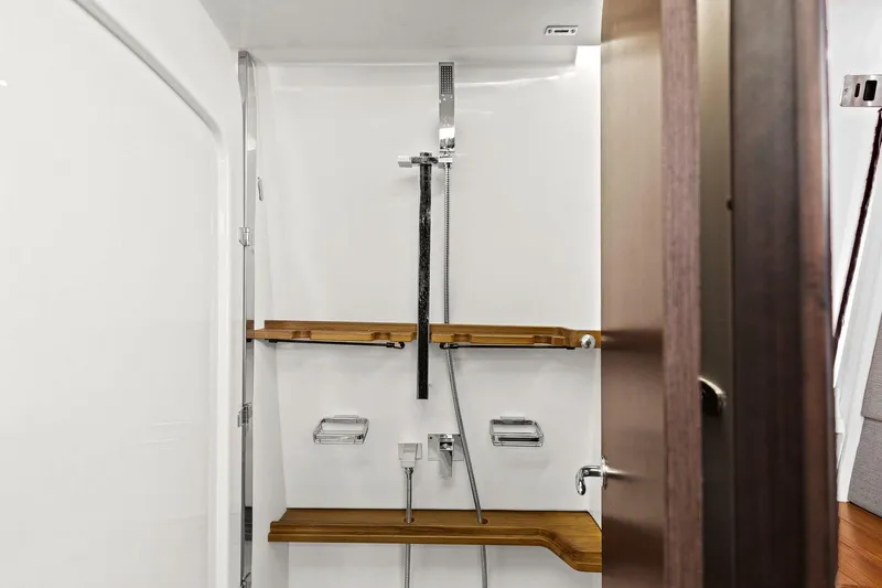  Yacht Photos Pics 2023 Grady-White Canyon 456 shower with wooden shelves and modern fixtures.
