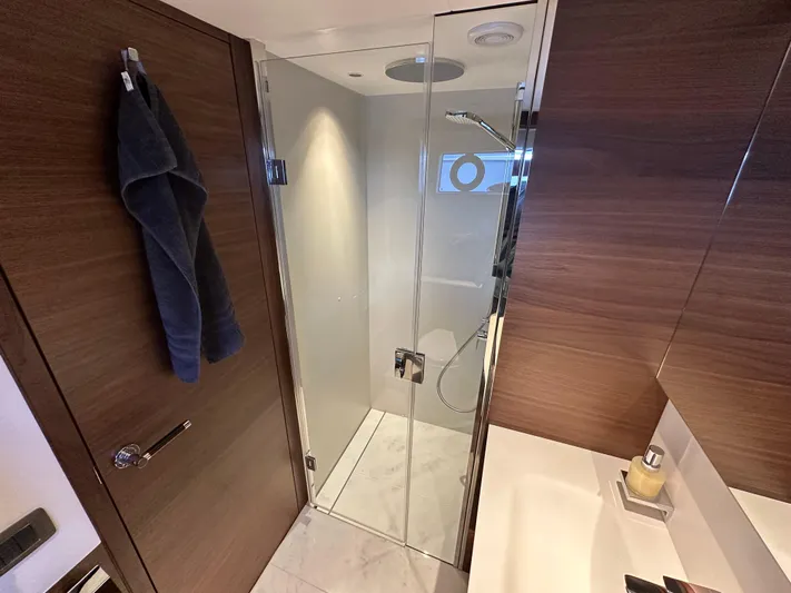  Yacht Photos Pics Luxurious bathroom in 2025 Princess Y80 yacht with glass shower and wooden accents.