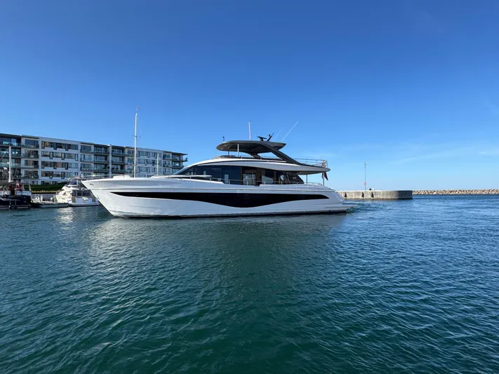  Yacht Photos Pics 2025 Princess Y80 yacht docked in marina, clear blue sky, modern waterfront buildings.