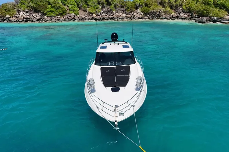 Yacht Photos Pics 2006 Sea Ray 480 Sundancer yacht anchored in clear turquoise waters near a rocky shoreline.