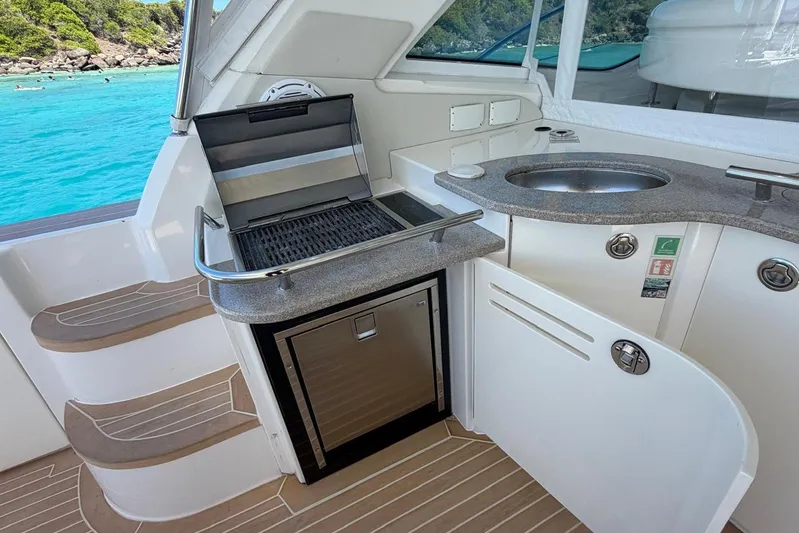  Yacht Photos Pics Outdoor kitchen on 2006 Sea Ray 480 Sundancer yacht with grill and sink, near turquoise water.
