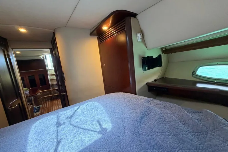  Yacht Photos Pics Interior cabin of 2006 Sea Ray 480 Sundancer yacht, featuring cozy bed and wooden accents.