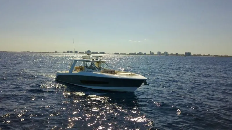  Yacht Photos Pics 2019 Boston Whaler 420 Outrage cruising on open water with city skyline in background.