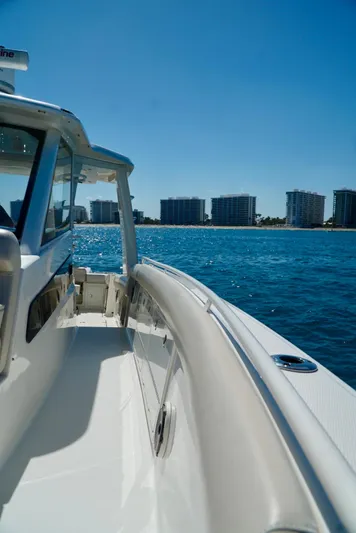  Yacht Photos Pics 2019 Boston Whaler 420 Outrage cruising on blue water near coastal buildings.