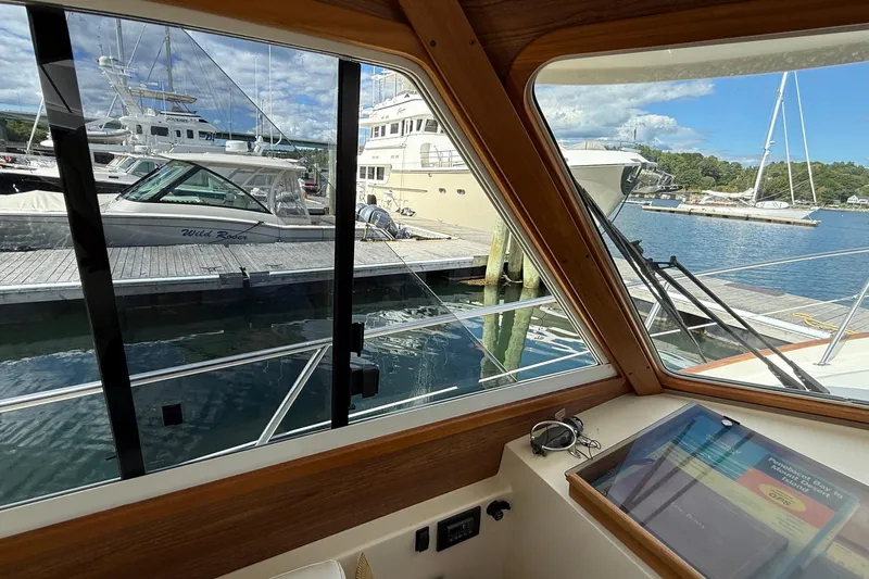 Tova Yacht Photos Pics Interior view from 2007 Legacy Yachts 32 Sedan, overlooking marina with boats docked.