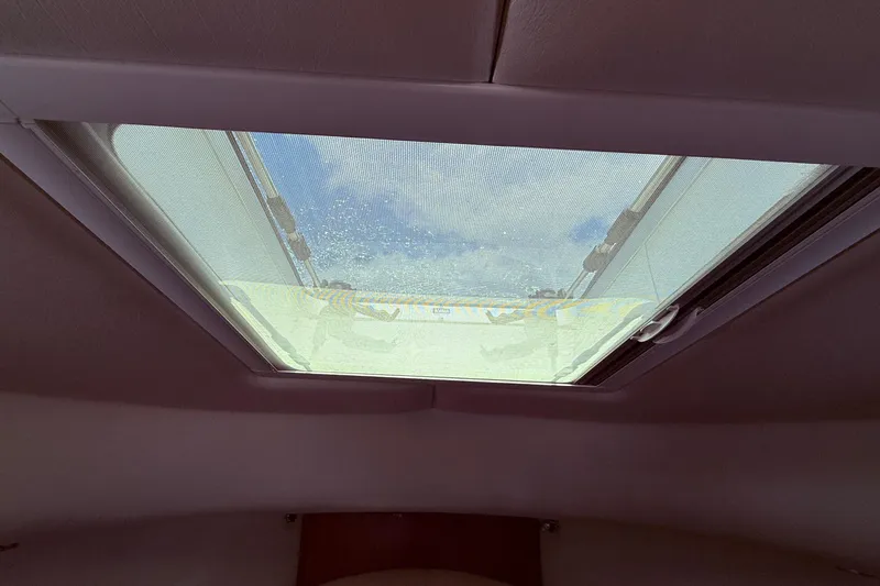 Tova Yacht Photos Pics Skylight view from 2007 Legacy Yachts 32 Sedan, showcasing blue sky and clouds.