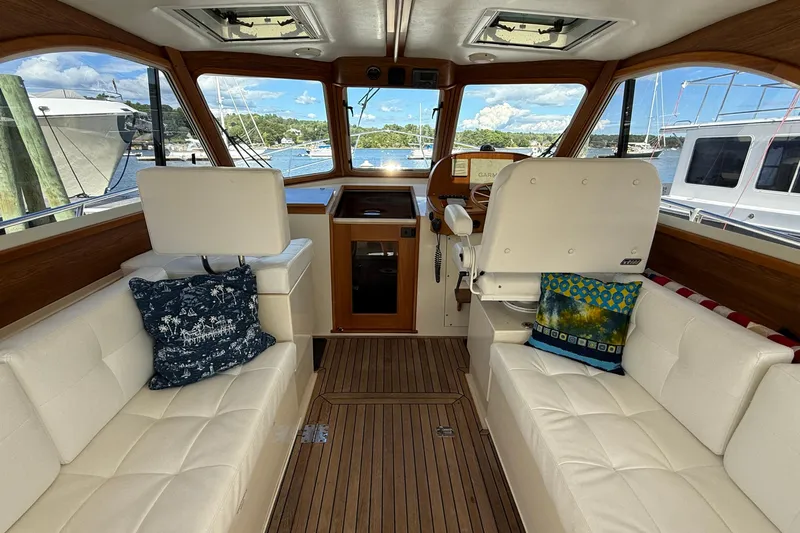 Tova Yacht Photos Pics Interior of 2007 Legacy Yachts 32 Sedan with white seating and scenic marina view.