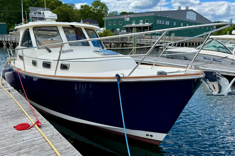 Tova Yacht Photos Pics 2007 Legacy Yachts 32 Sedan docked at a marina, featuring a sleek blue hull.