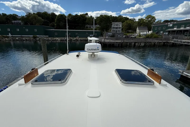 Tova Yacht Photos Pics 2007 Legacy Yachts 32 Sedan on calm water with Garmin equipment, docked near green buildings.