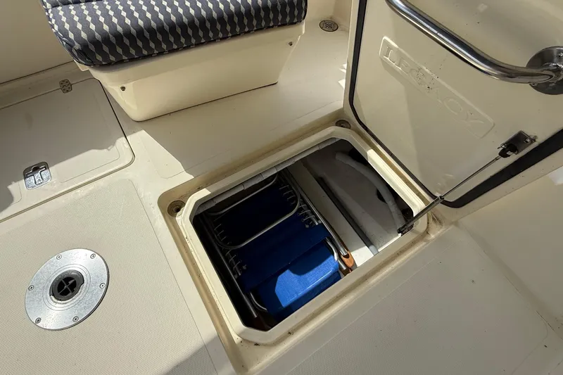 Tova Yacht Photos Pics Open storage compartment on 2007 Legacy Yachts 32 Sedan, featuring blue folding chairs.