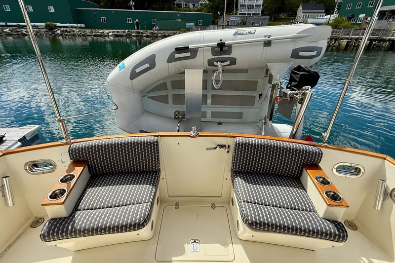 Tova Yacht Photos Pics 2007 Legacy Yachts 32 Sedan cockpit with seating and inflatable boat on calm water.