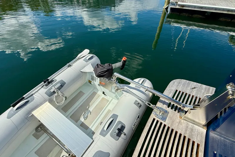 Tova Yacht Photos Pics Inflatable boat docked beside 2007 Legacy Yachts 32 Sedan, reflecting on calm water.