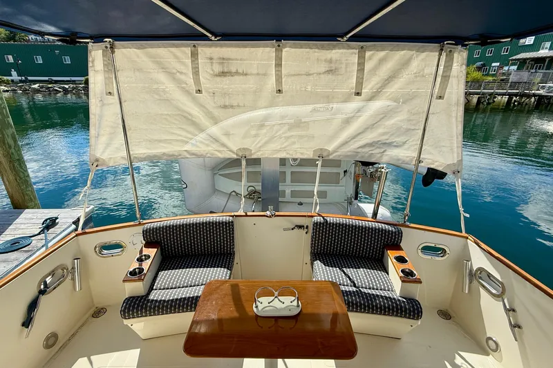 Tova Yacht Photos Pics 2007 Legacy Yachts 32 Sedan cockpit with seating, table, and waterfront view.