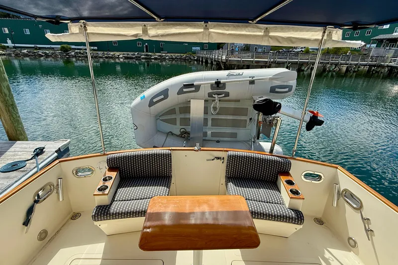 Tova Yacht Photos Pics 2007 Legacy Yachts 32 Sedan cockpit with seating, table, and docked inflatable boat.