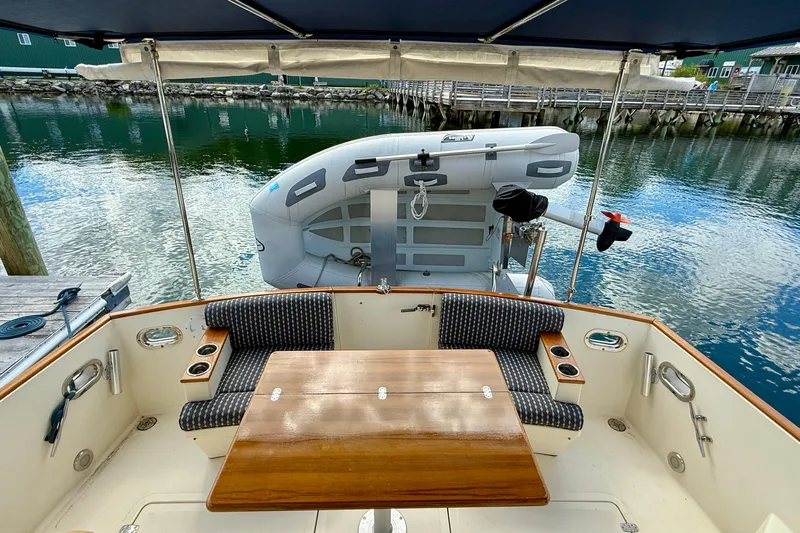 Tova Yacht Photos Pics 2007 Legacy Yachts 32 Sedan cockpit with seating, table, and docked inflatable boat.