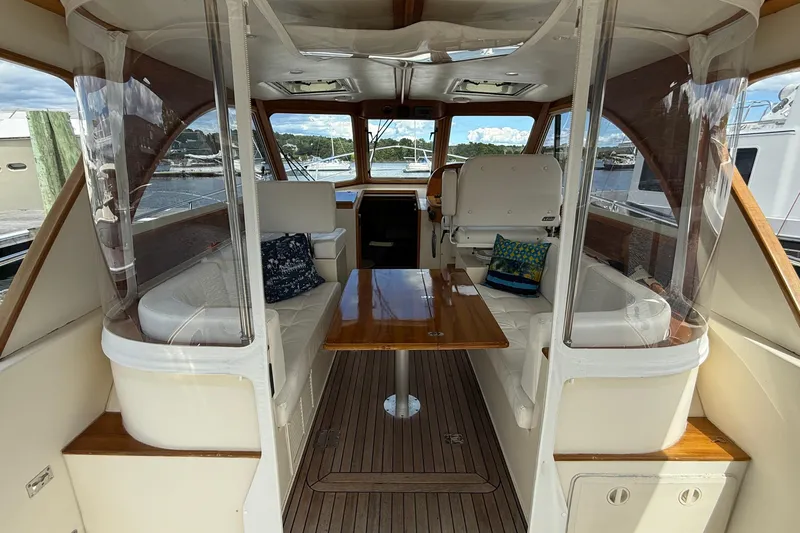 Tova Yacht Photos Pics 2007 Legacy Yachts 32 Sedan interior with seating, table, and helm station.