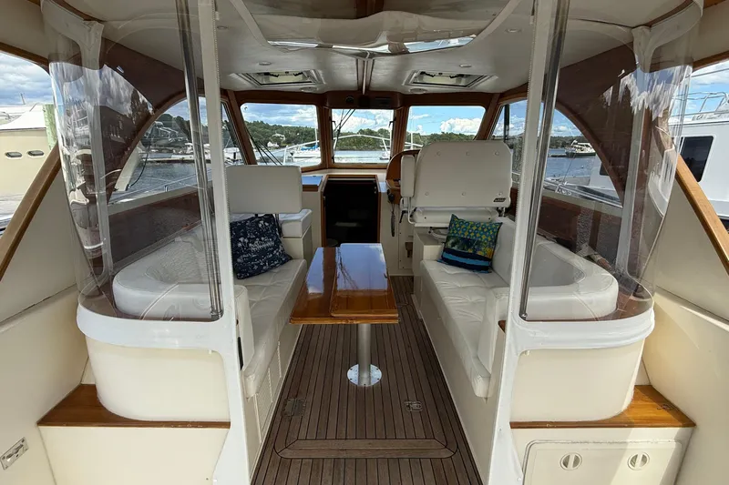 Tova Yacht Photos Pics 2007 Legacy Yachts 32 Sedan interior with seating, wooden table, and clear windows.