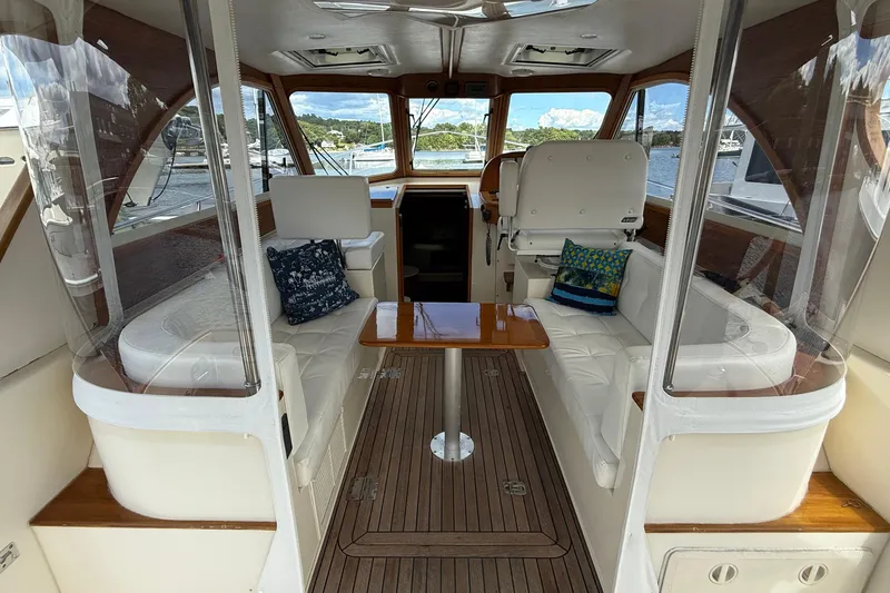 Tova Yacht Photos Pics Interior of 2007 Legacy Yachts 32 Sedan with white seating and wooden accents.