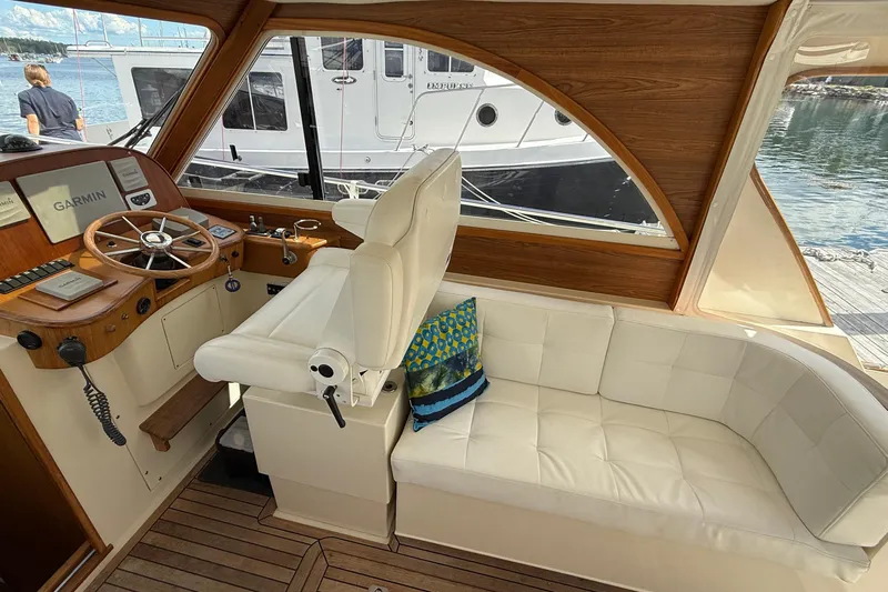 Tova Yacht Photos Pics Interior of 2007 Legacy Yachts 32 Sedan with helm, seating, and wood accents.