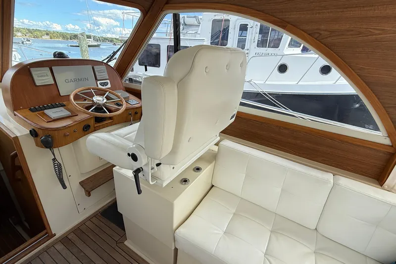 Tova Yacht Photos Pics 2007 Legacy Yachts 32 Sedan helm with Garmin navigation, white seating, and wooden accents.