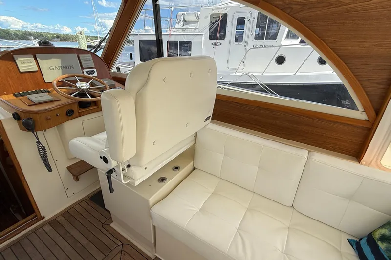 Tova Yacht Photos Pics 2007 Legacy Yachts 32 Sedan interior with helm, white seating, and Garmin navigation.