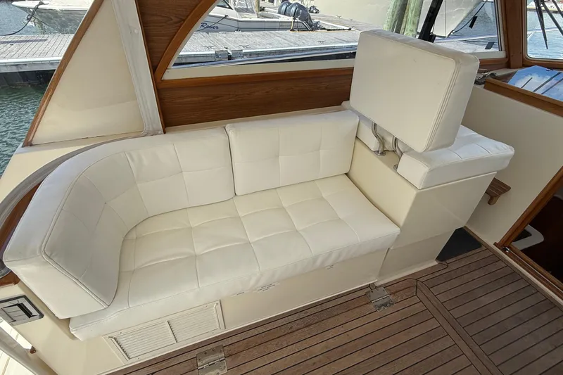 Tova Yacht Photos Pics White cushioned seating on 2007 Legacy Yachts 32 Sedan, featuring wooden interior accents.