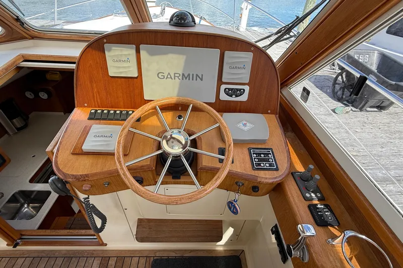 Tova Yacht Photos Pics 2007 Legacy Yachts 32 Sedan helm with Garmin navigation system and wooden steering wheel.
