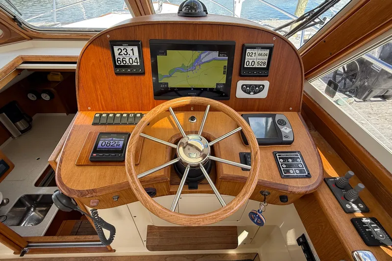 Tova Yacht Photos Pics 2007 Legacy Yachts 32 Sedan helm with wooden steering wheel and navigation instruments.