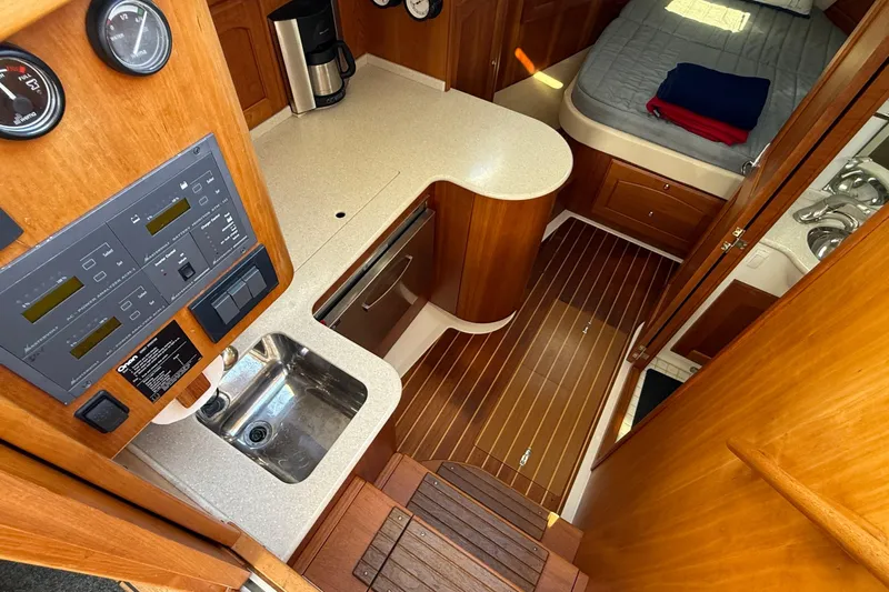 Tova Yacht Photos Pics 2007 Legacy Yachts 32 Sedan interior with wood finish, kitchenette, and sleeping area.