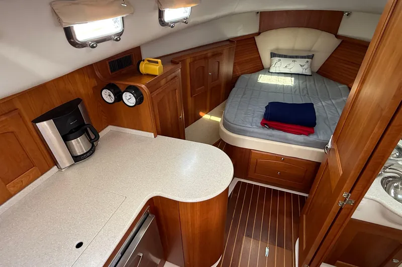 Tova Yacht Photos Pics Interior of 2007 Legacy Yachts 32 Sedan with cozy bed and kitchenette.