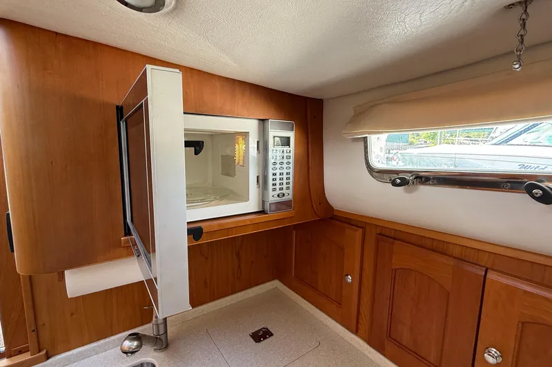 Tova Yacht Photos Pics 2007 Legacy Yachts 32 Sedan interior with microwave and wooden cabinetry.
