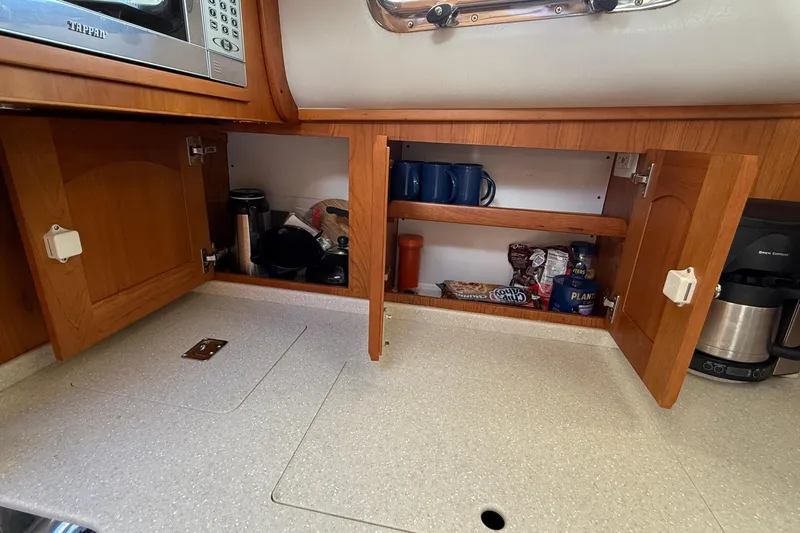 Tova Yacht Photos Pics 2007 Legacy Yachts 32 Sedan kitchen with open cabinets and countertop appliances.