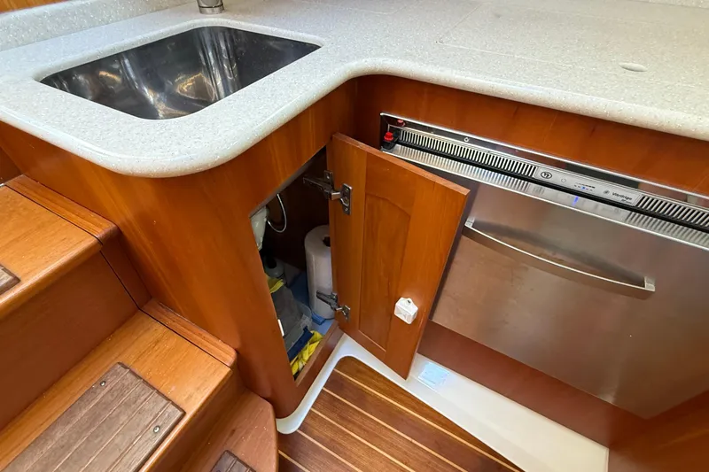 Tova Yacht Photos Pics 2007 Legacy Yachts 32 Sedan kitchen with sink, dishwasher, and wooden cabinetry.