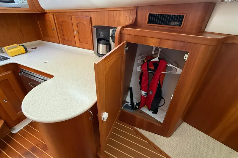 Tova Yacht Photos Pics 2007 Legacy Yachts 32 Sedan interior with wooden cabinetry and life jacket storage.