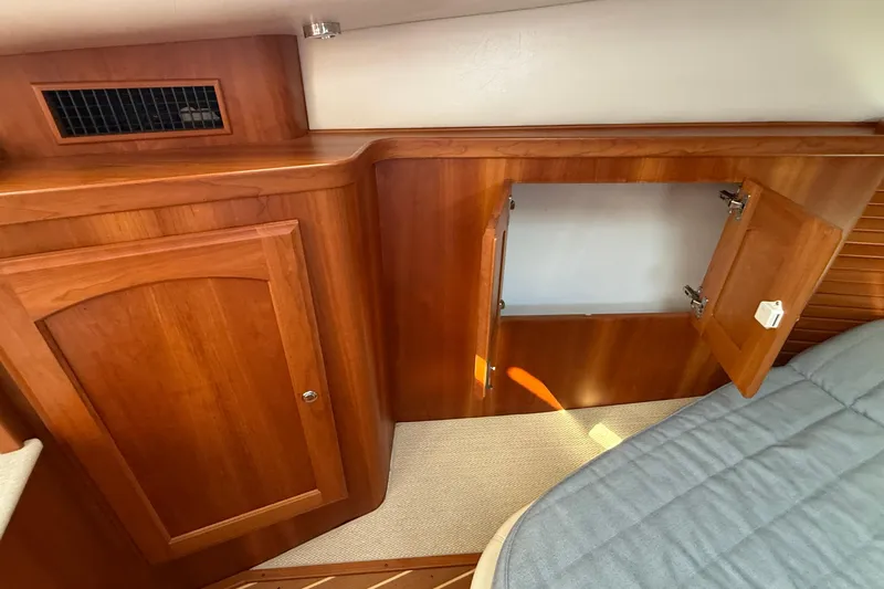 Tova Yacht Photos Pics Interior of 2007 Legacy Yachts 32 Sedan with wooden cabinetry and open storage compartment.