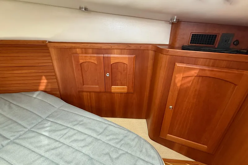 Tova Yacht Photos Pics Interior of 2007 Legacy Yachts 32 Sedan with wooden cabinetry and bed.