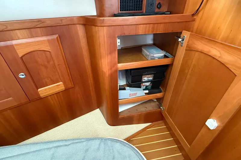 Tova Yacht Photos Pics Wooden cabinet interior on 2007 Legacy Yachts 32 Sedan, showcasing storage shelves.